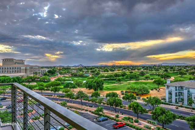 balcony at dusk featuring a mountain view and golf course view