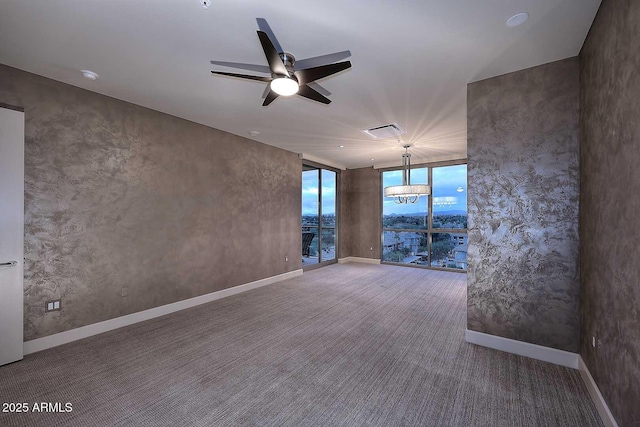 carpeted empty room featuring a ceiling fan and baseboards