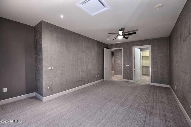 carpeted empty room featuring ceiling fan and baseboards