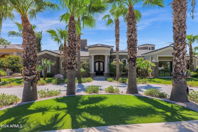 mediterranean / spanish home featuring a front lawn