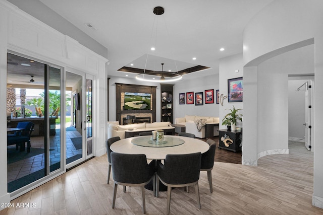 dining space featuring a tray ceiling and light hardwood / wood-style flooring