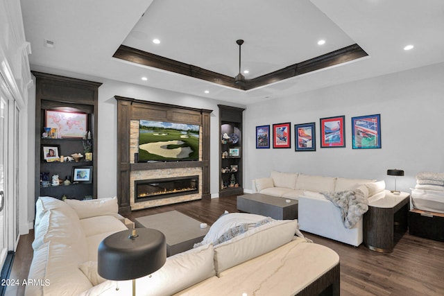 living room with dark hardwood / wood-style floors and a raised ceiling