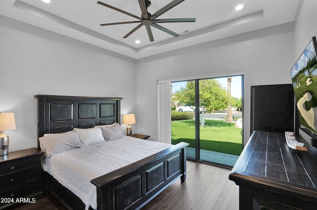 bedroom featuring a tray ceiling, ceiling fan, hardwood / wood-style flooring, and access to outside