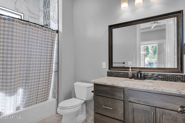 full bathroom featuring vanity, toilet, shower / tub combo, and ceiling fan