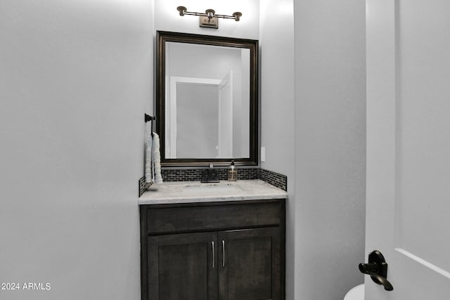 bathroom featuring vanity and backsplash