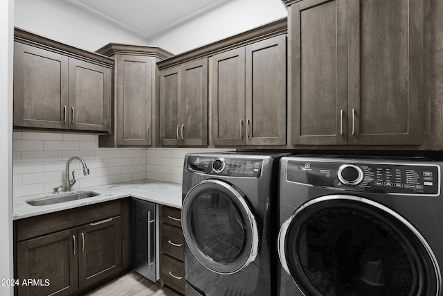 laundry area featuring cabinets, washing machine and dryer, and sink