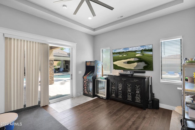 entrance foyer with a tray ceiling, dark hardwood / wood-style flooring, beverage cooler, and ceiling fan