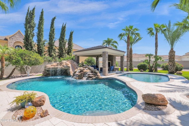 view of pool with a patio and pool water feature