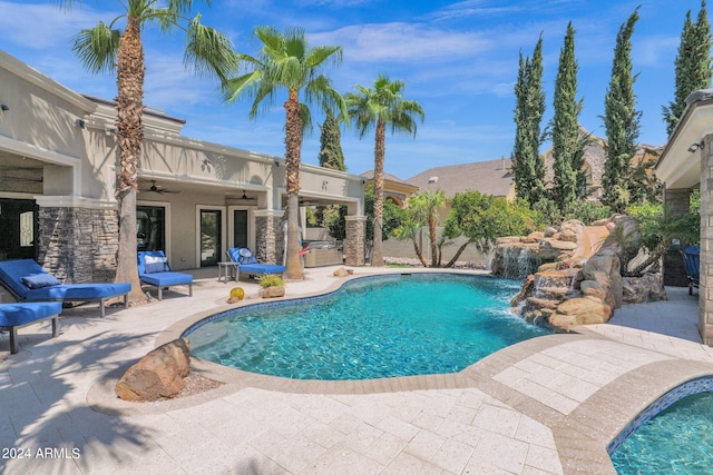 view of pool featuring pool water feature, ceiling fan, and a patio