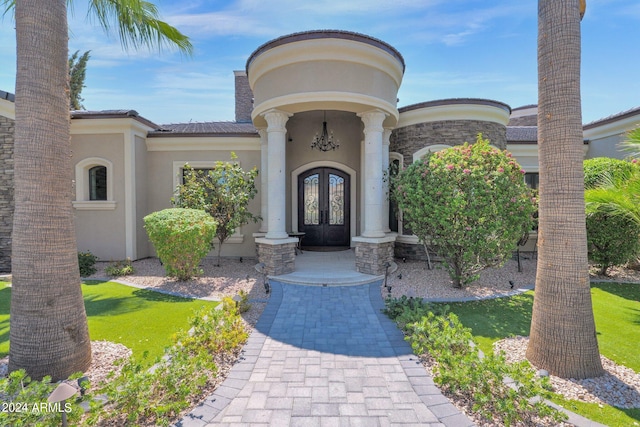 entrance to property with a yard and french doors