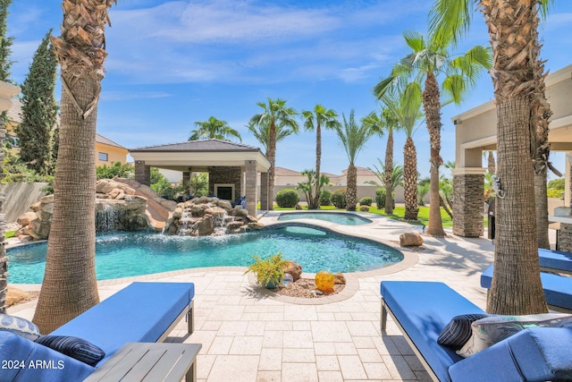 view of pool with pool water feature, a patio, and an in ground hot tub