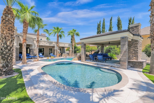 view of pool with ceiling fan and a patio