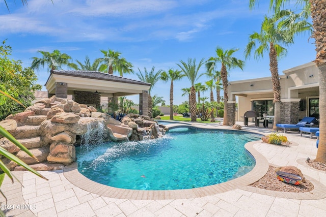 view of swimming pool with a patio area, ceiling fan, and pool water feature