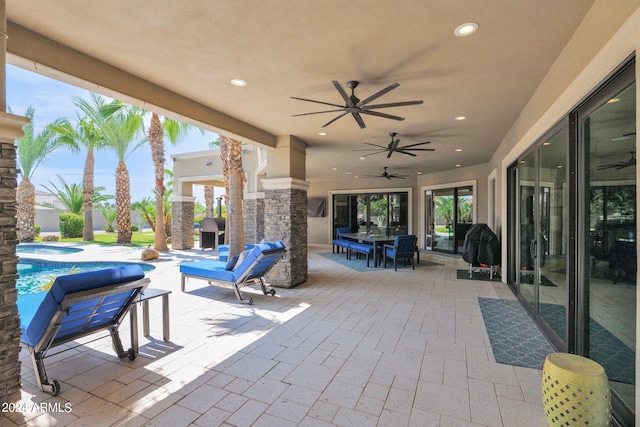 view of patio with a fireplace and ceiling fan