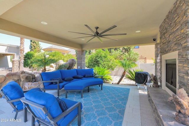 view of patio featuring an outdoor living space with a fireplace and ceiling fan