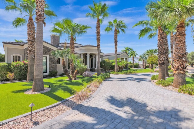 3749 E Juniper Cir, Mesa, AZ 85205 - view of front of home with stucco siding, stone siding, decorative driveway, a front lawn, and a chimney