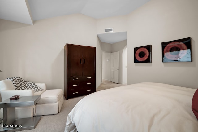 bedroom featuring light carpet and vaulted ceiling