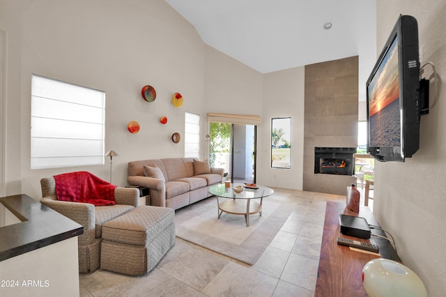 living room with a fireplace, high vaulted ceiling, and light tile patterned flooring