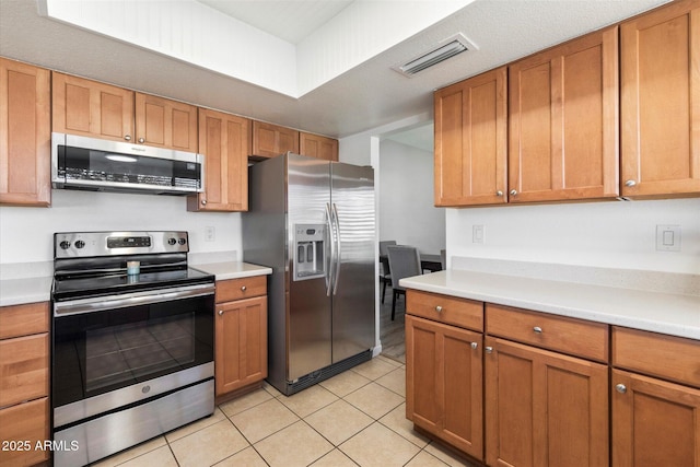 kitchen with stainless steel appliances and light tile patterned flooring