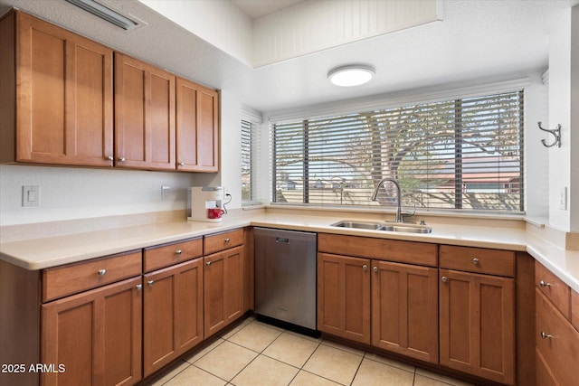 kitchen featuring sink, light tile patterned flooring, stainless steel dishwasher, and plenty of natural light