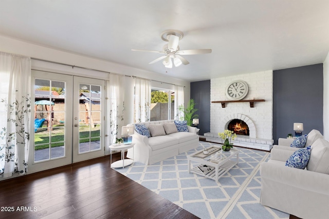 living room featuring ceiling fan, french doors, dark hardwood / wood-style floors, and a fireplace