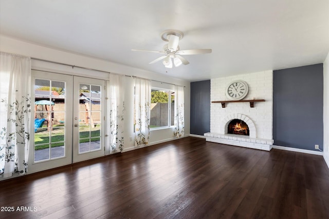 unfurnished living room featuring ceiling fan, french doors, dark hardwood / wood-style floors, and a fireplace