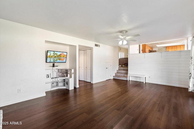 unfurnished living room with dark wood-type flooring and ceiling fan