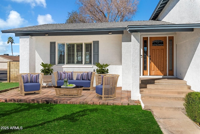 view of exterior entry with outdoor lounge area and a yard