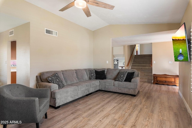 living room featuring ceiling fan, light wood-type flooring, and lofted ceiling