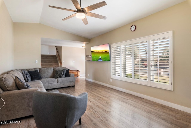 living room featuring ceiling fan, light hardwood / wood-style flooring, and lofted ceiling