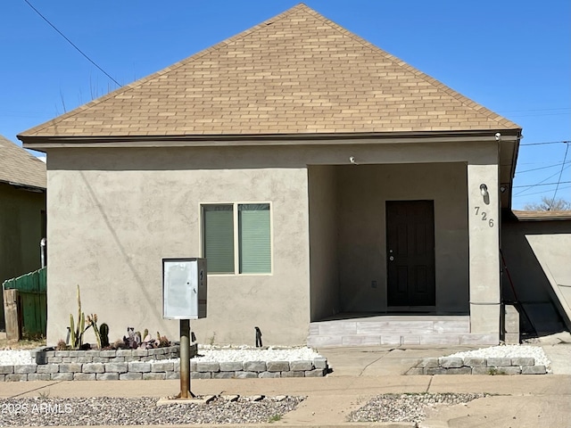 back of property featuring roof with shingles and stucco siding