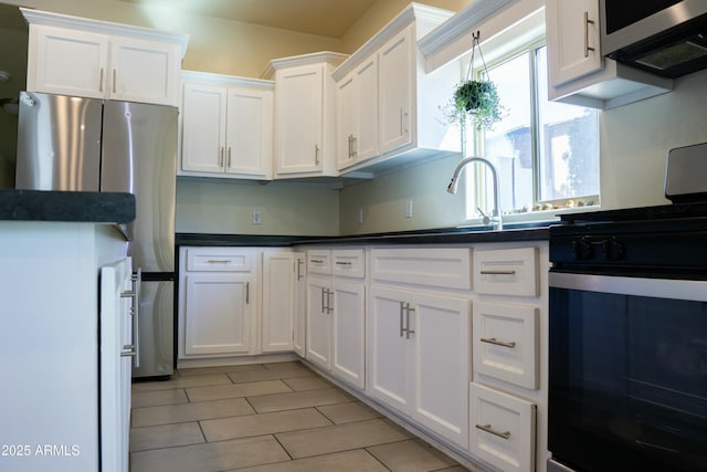 kitchen with dark countertops, white cabinets, and stainless steel appliances