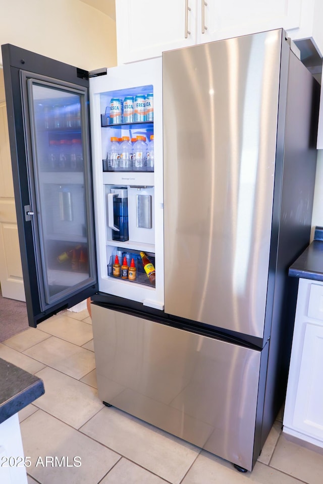 details with dark countertops, freestanding refrigerator, and white cabinetry