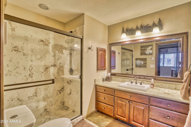 full bath featuring toilet, a stall shower, vanity, a textured ceiling, and baseboards