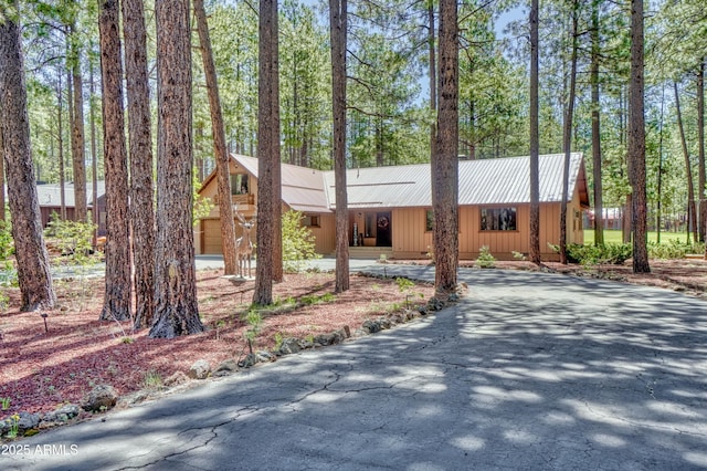 view of front facade with driveway and metal roof