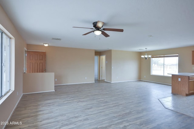 empty room with light wood finished floors, baseboards, and visible vents