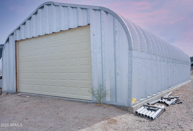 view of garage at dusk