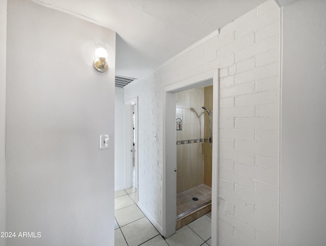 bathroom featuring tile patterned flooring and a tile shower