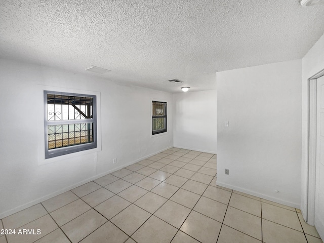 tiled spare room with a textured ceiling