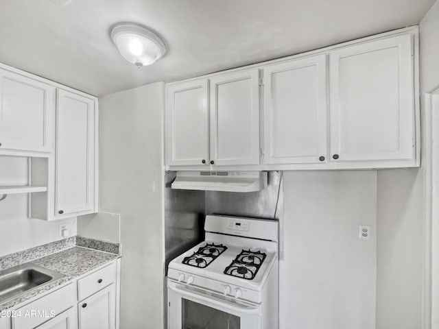 kitchen with white cabinets, sink, and white gas stove