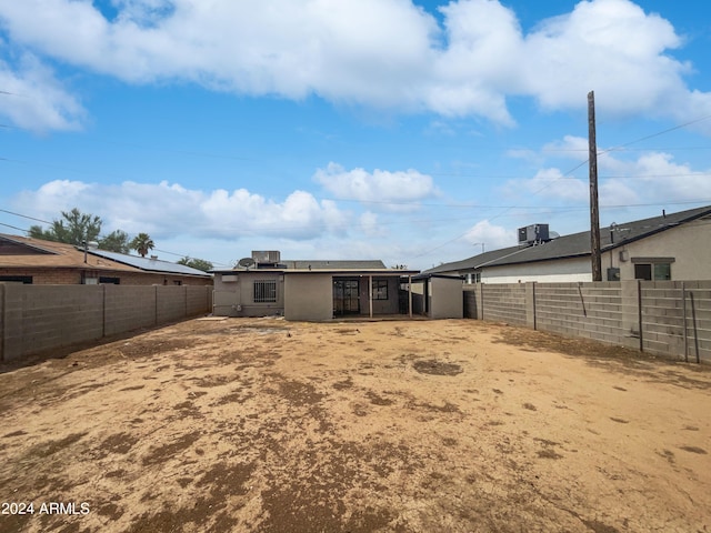 rear view of property with central AC