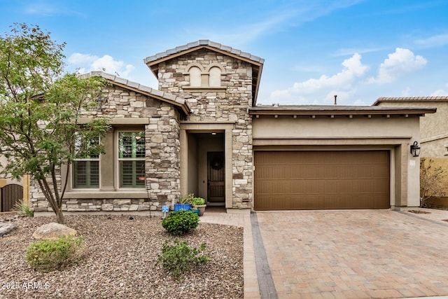 view of front of home with a garage, stone siding, decorative driveway, and stucco siding