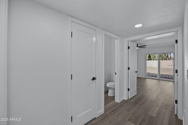 hallway featuring a textured ceiling and hardwood / wood-style flooring