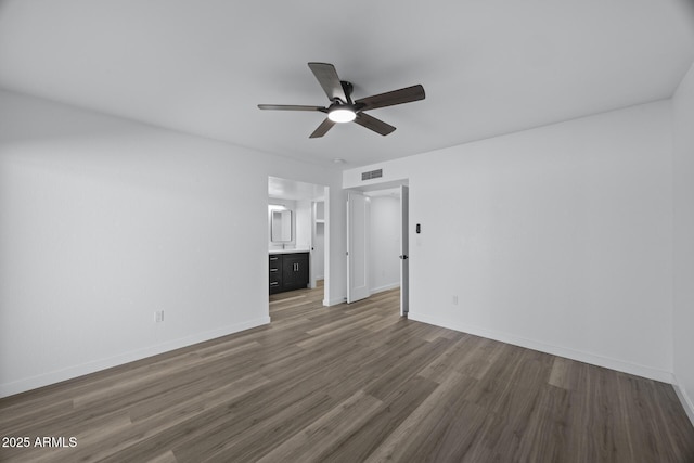 empty room with ceiling fan and dark hardwood / wood-style flooring