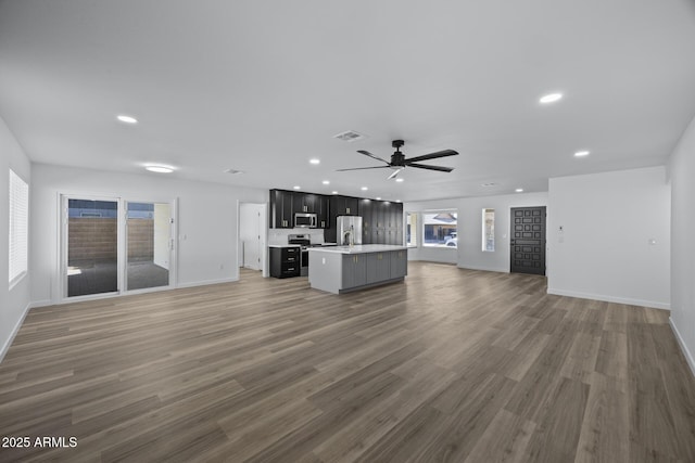 unfurnished living room featuring ceiling fan and dark hardwood / wood-style floors