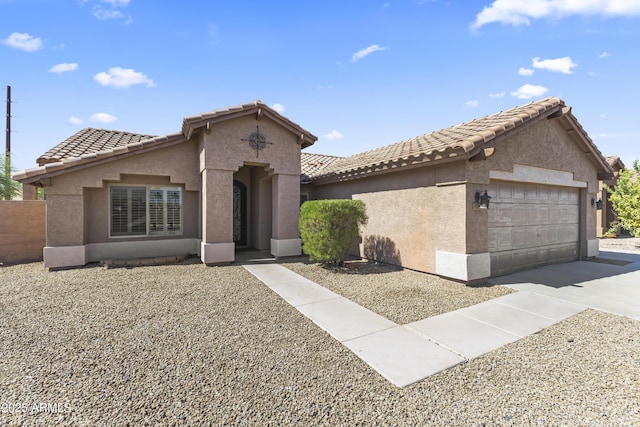 mediterranean / spanish-style house with an attached garage, stucco siding, concrete driveway, and a tiled roof