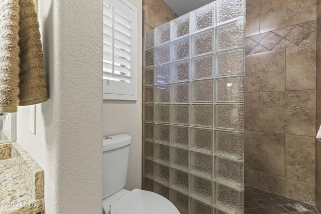 bathroom featuring walk in shower and toilet