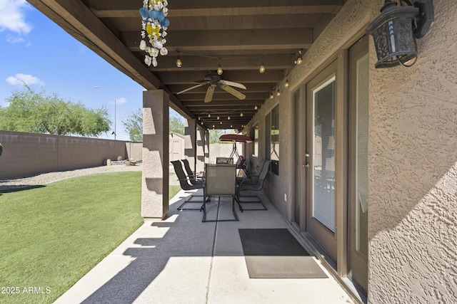 view of patio featuring a storage shed, outdoor dining area, an outbuilding, and a ceiling fan
