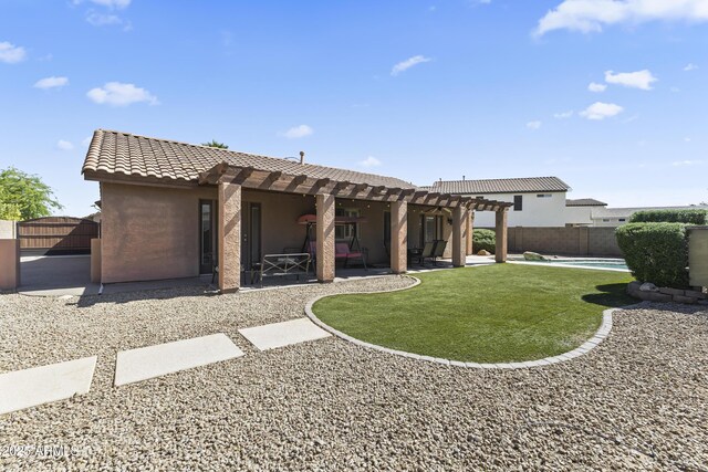 back of property with a pergola, stucco siding, a tile roof, and a patio area
