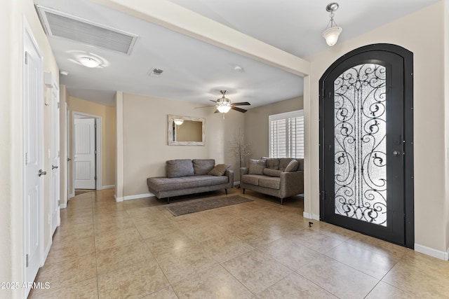 foyer entrance with light tile patterned floors, baseboards, ceiling fan, and arched walkways